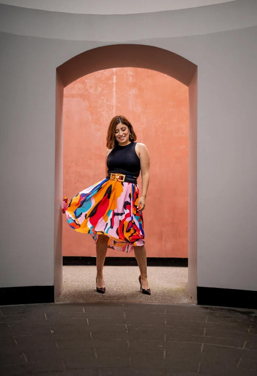 a person standing by a archway holding a dress