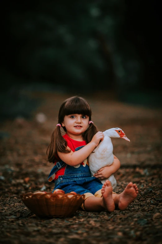 a little girl holding onto a small bird