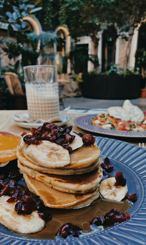 pancakes sitting on a plate on a table next to fruit