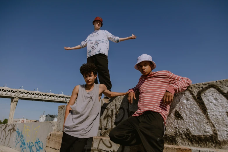 three people posing in front of a wall