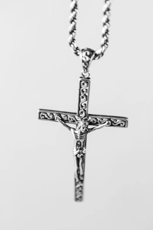 a silver cross necklace with a decorative bead