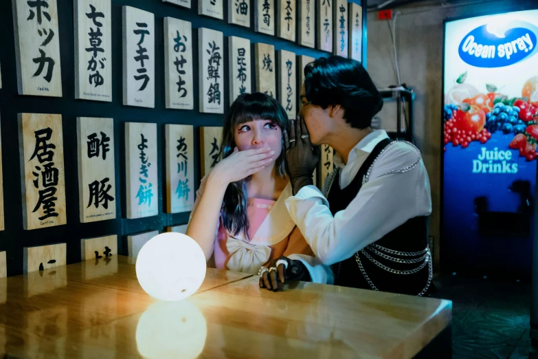 a woman looking at another woman in front of wall covered with signs