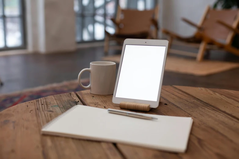 a cup, pen, and electronic device on a table