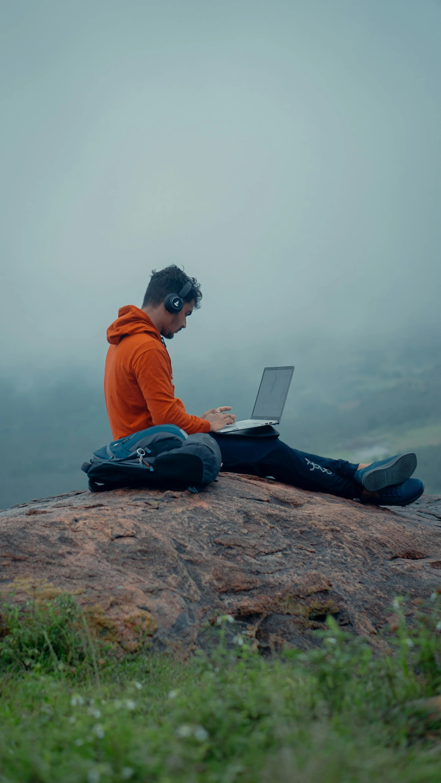 a man with his laptop on a misty day