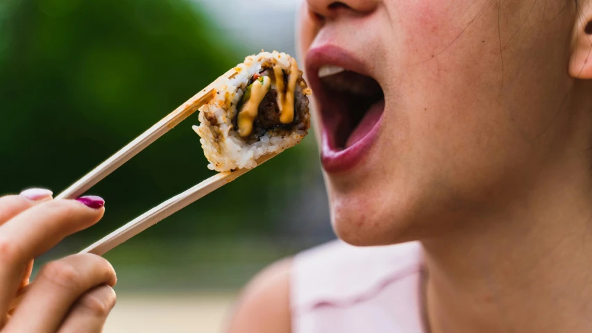 a woman is holding a food item and a spoon