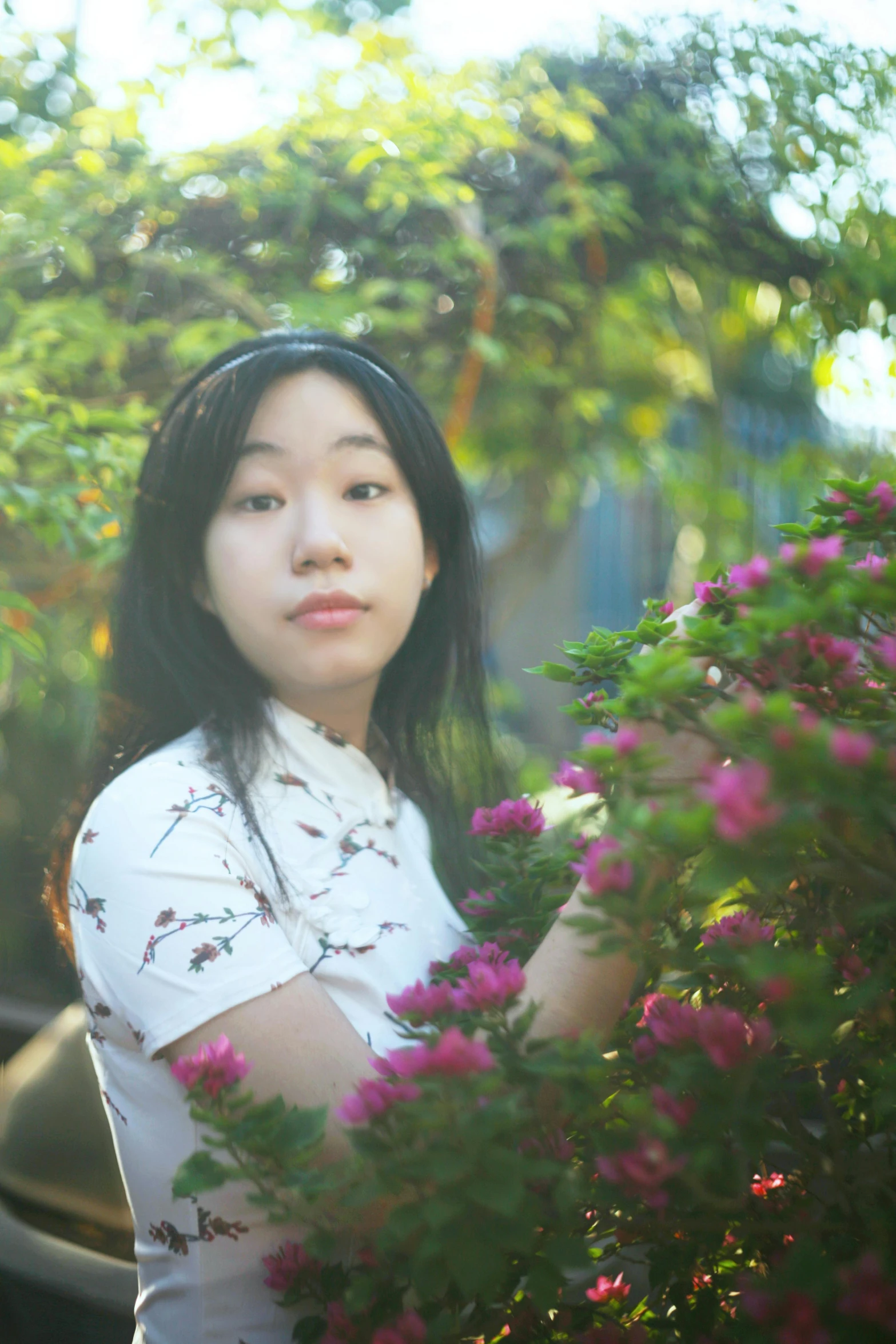 a girl in a white top is surrounded by purple flowers