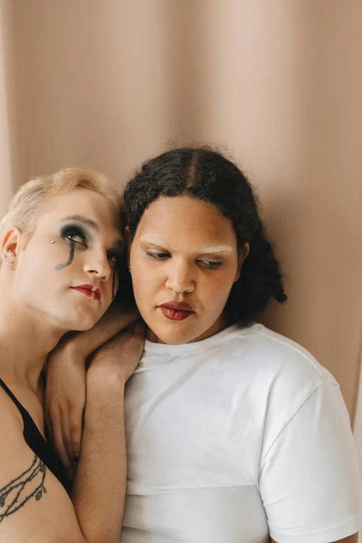 two women with face makeup are standing next to each other