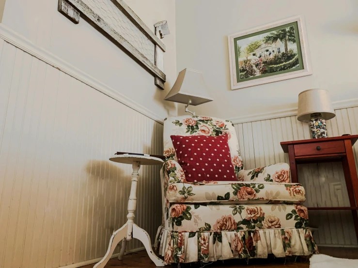 a chair and table next to wall with a flower patterned design