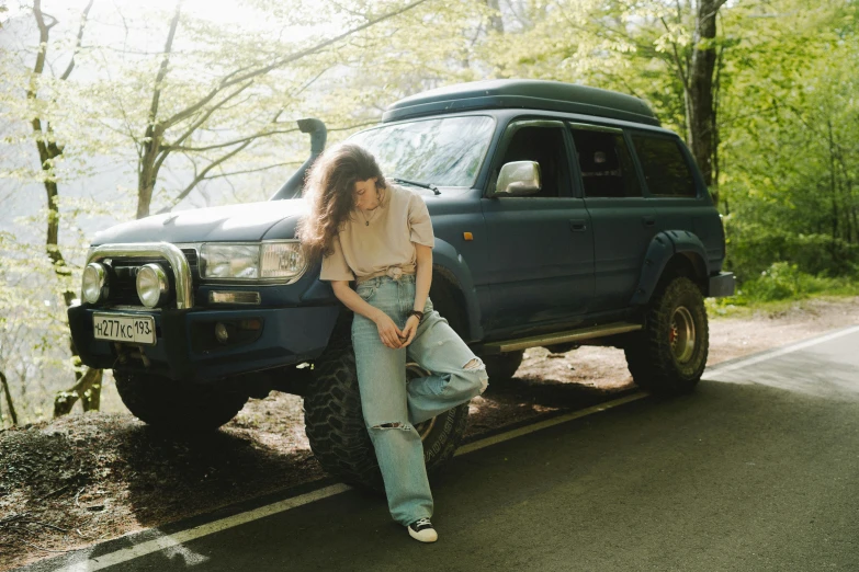 a woman sitting on the hood of a blue truck