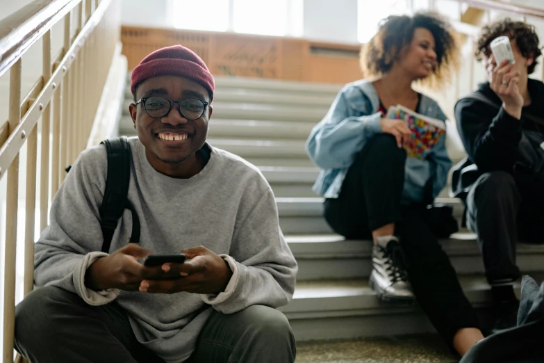 a man and woman smiling as they both play a game on their cell phones