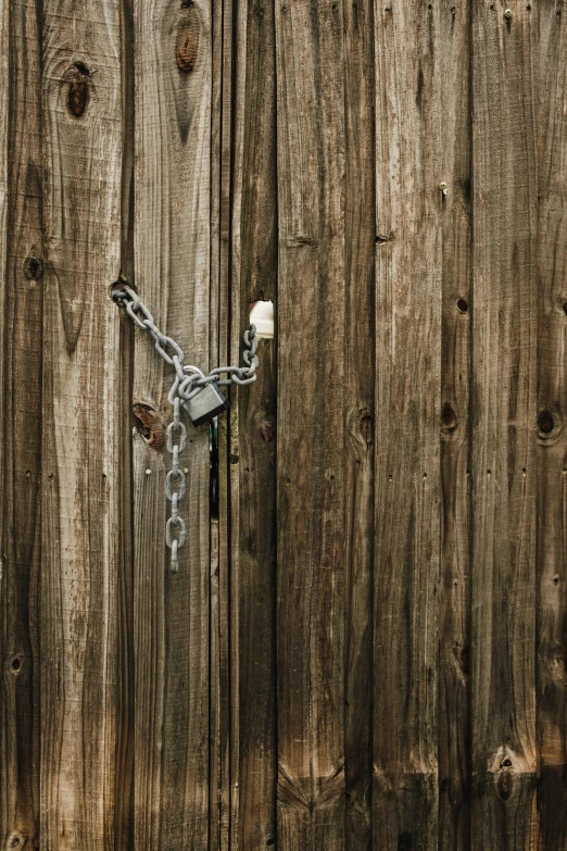 the chain is hanging from the lock on the wood