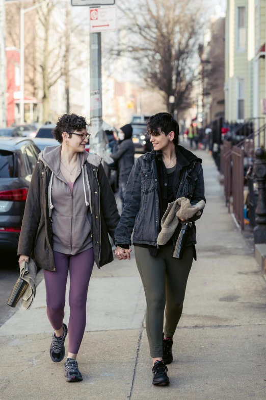 two women walking down the street holding hands