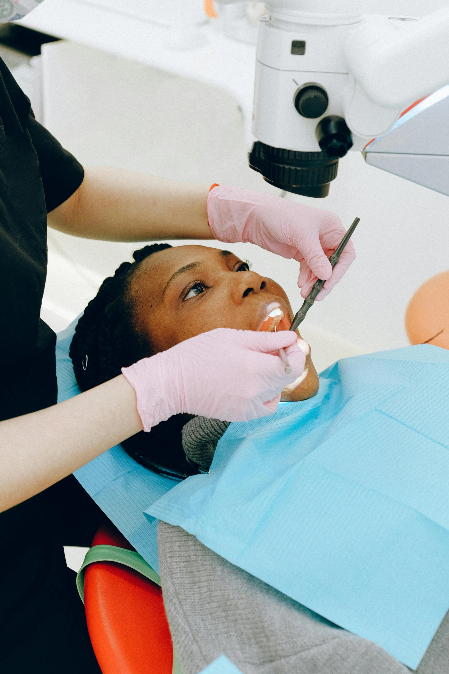 a woman sitting in a chair at a dentist's office with a  his hair