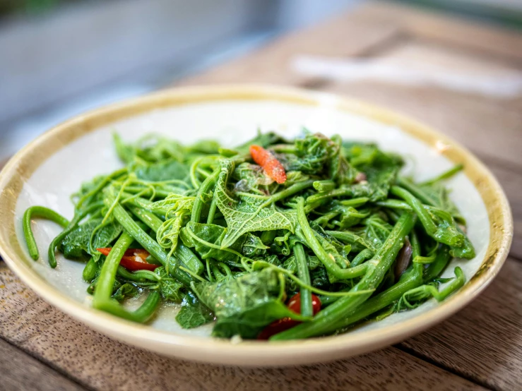 a green salad is being displayed on a wooden table