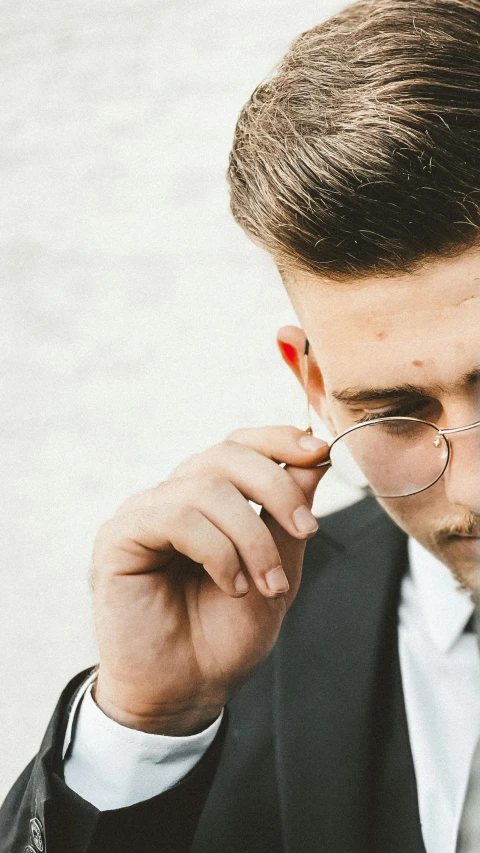 man in black suit with glasses and red lip