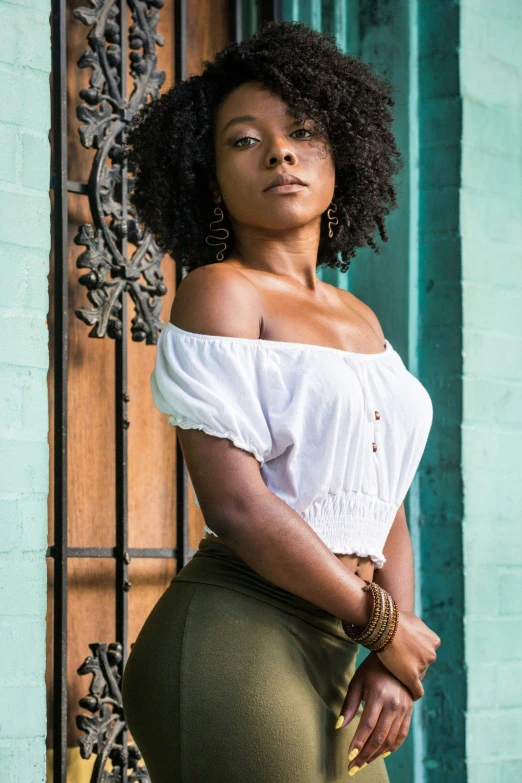 a young woman leaning on a wall posing for a picture