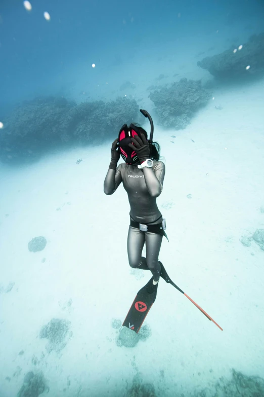 the person is wearing goggles and using a camera in the ocean