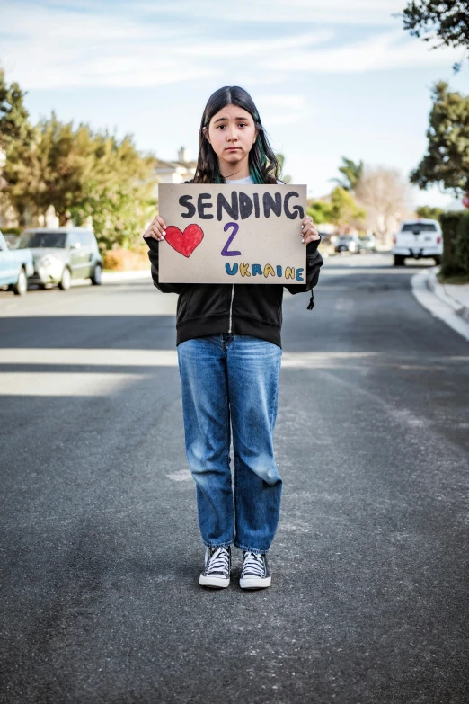a young person holding up a sign that reads sending 2 different kinds of love