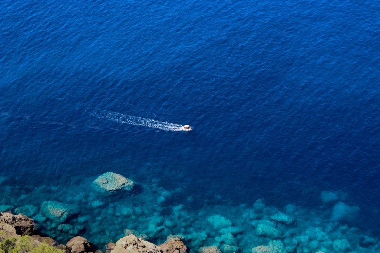 a boat floating on the ocean blue water