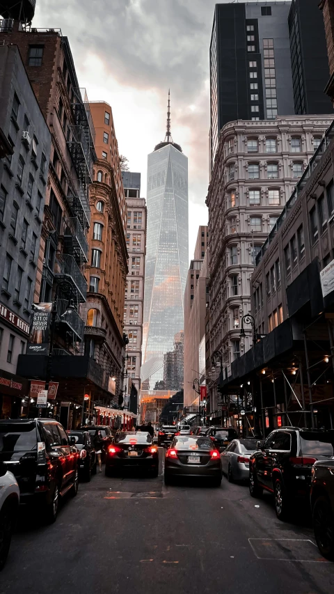 the street is crowded with cars and people walking down it