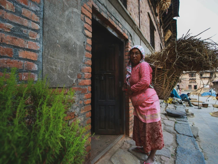 two women are leaning up against the door to enter the home