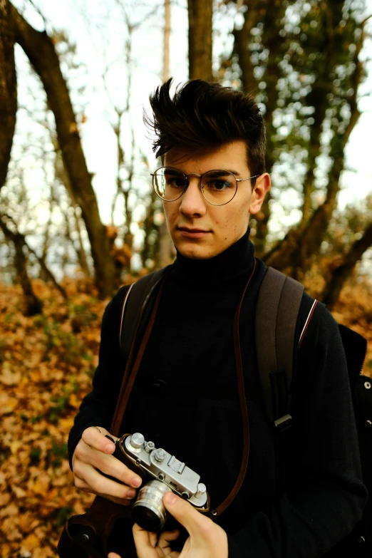 a man wearing glasses and holding a camera
