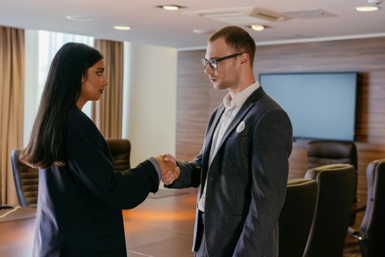 two people shaking hands in a conference room