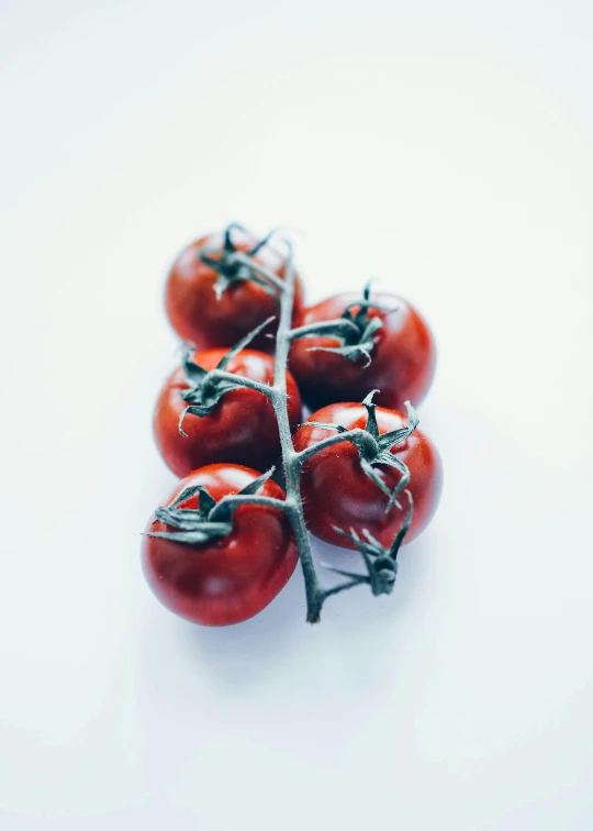 a bunch of four cherry tomatoes sit on top of each other