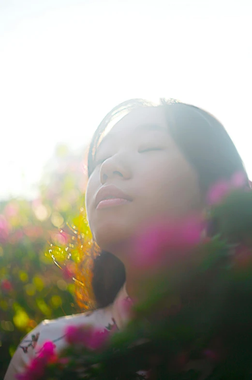 a close up of a person with a flower behind her