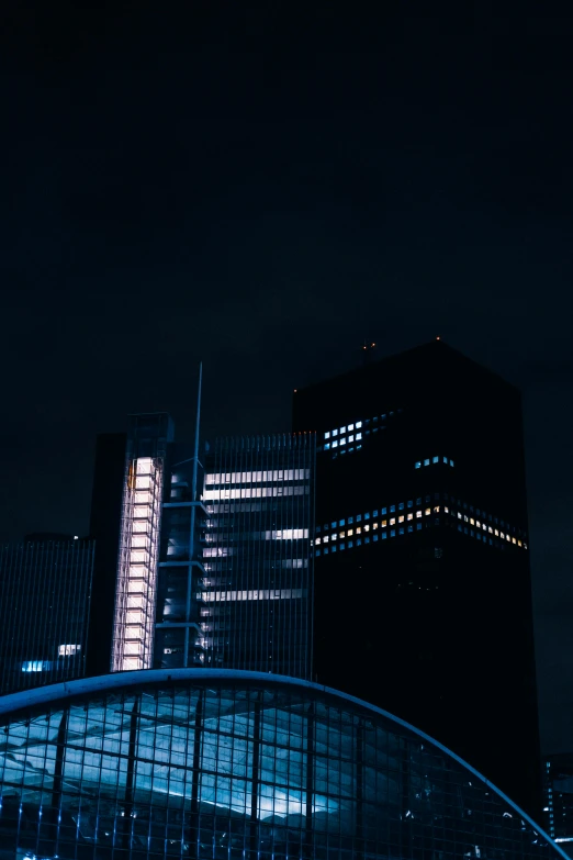 a po of two office buildings against a dark night sky