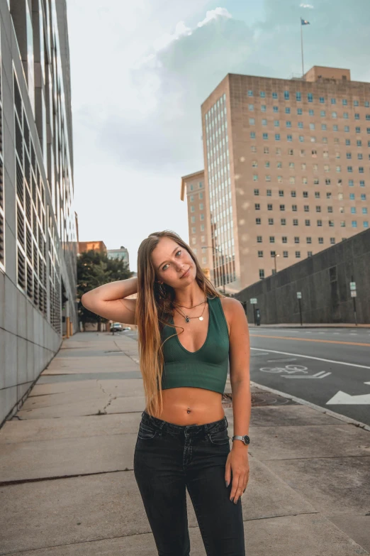 a young woman poses for a pograph in a city