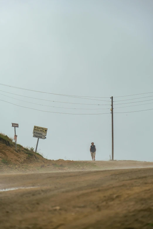 a man standing on top of a dirt road