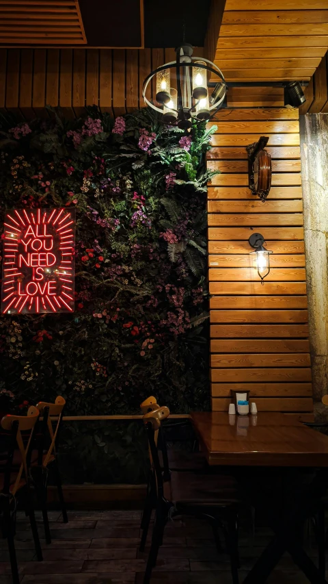 tables and chairs sitting in front of a wall with flowers on it