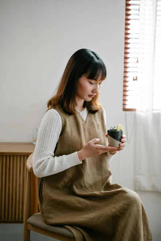 a woman sitting down and holding an item in her hands