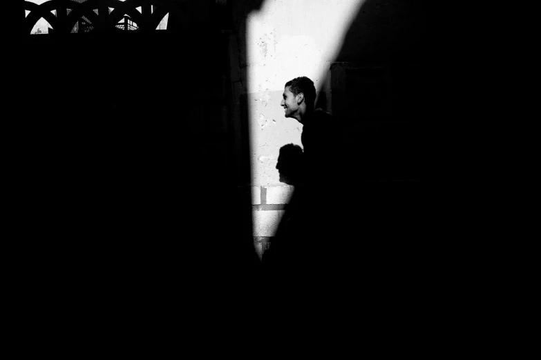 black and white pograph of man leaning on the wall