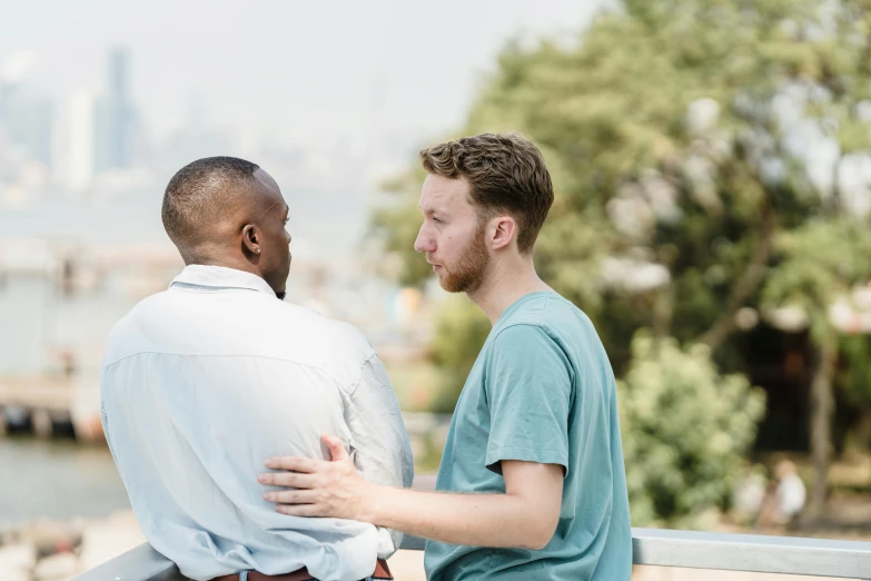 a man sitting on a railing watching another man emce