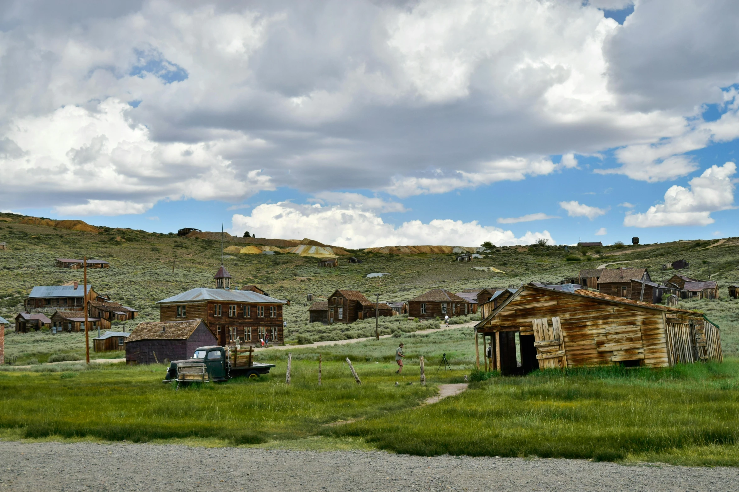 old wooden shacks and buildings in a grassy area