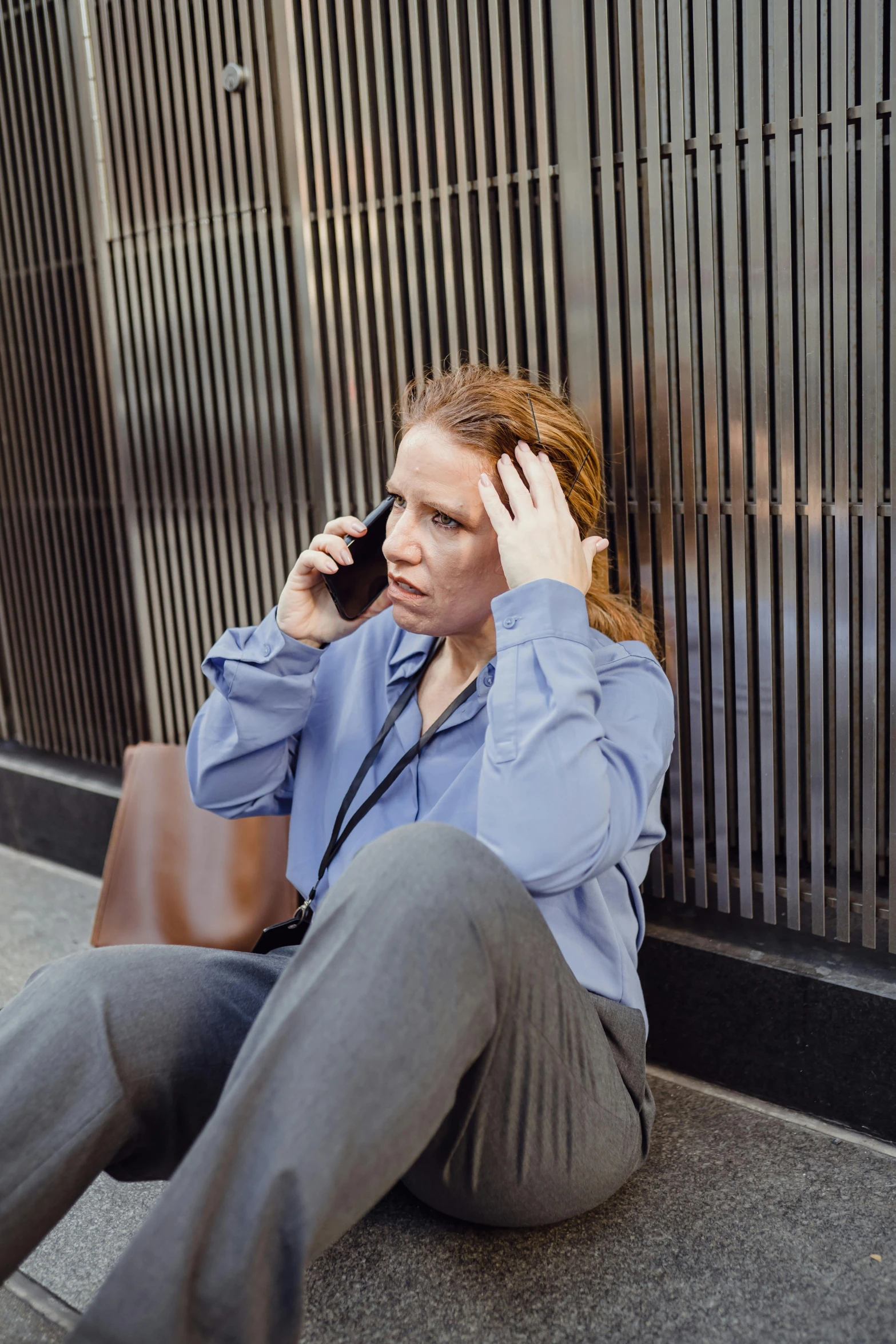 a lady sitting on the ground talking on her cell phone