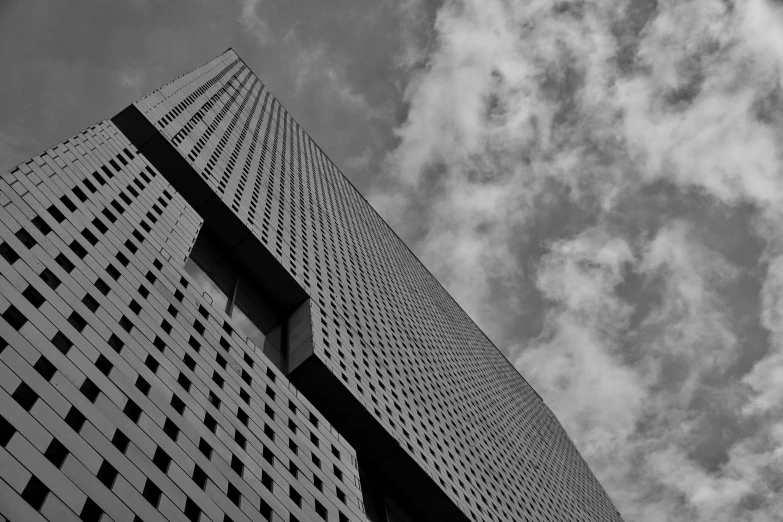 a tall skyscr standing under clouds on a clear day