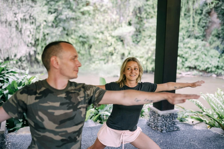 a man and woman are doing yoga outdoors