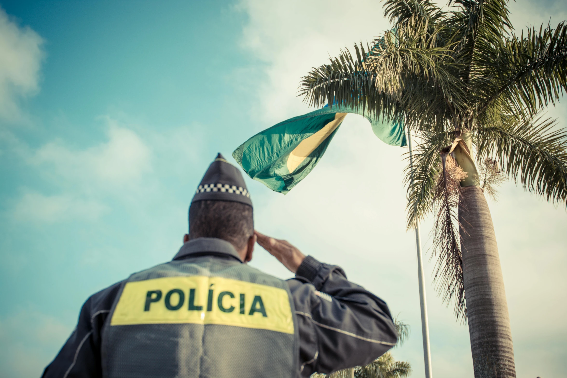 a police officer taking a pograph of a palm tree