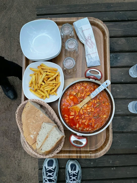 a tray has french fries, pasta and a slice of bread