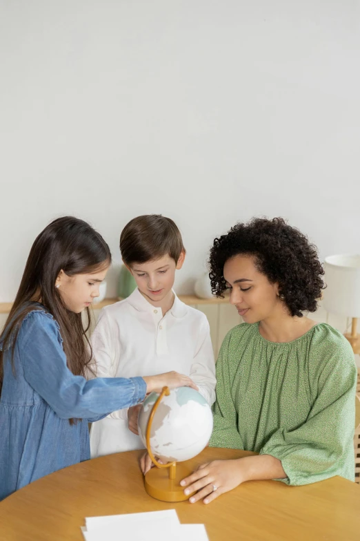 a family looking at a globe on a table