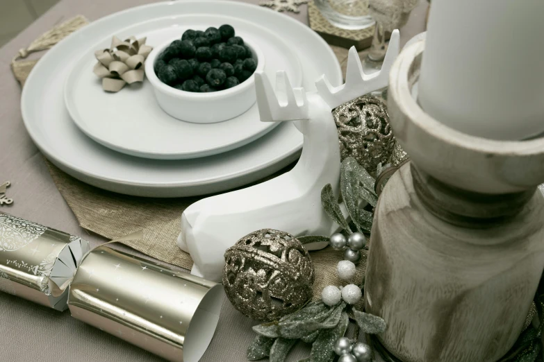 an empty plate next to candles and berries