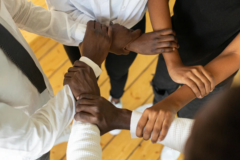 a group of people standing next to each other holding hands