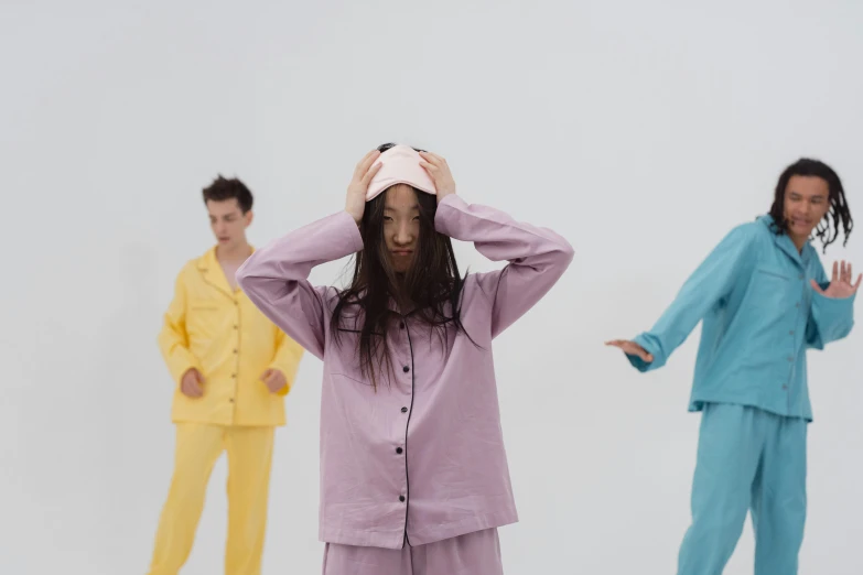 a man with long hair in pajamas standing in front of three other men