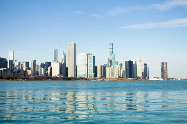 a cityscape in the background is reflected on water