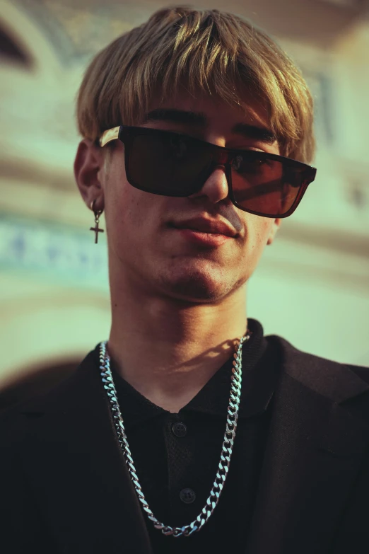 man with sunglasses wearing a long necklace and chain