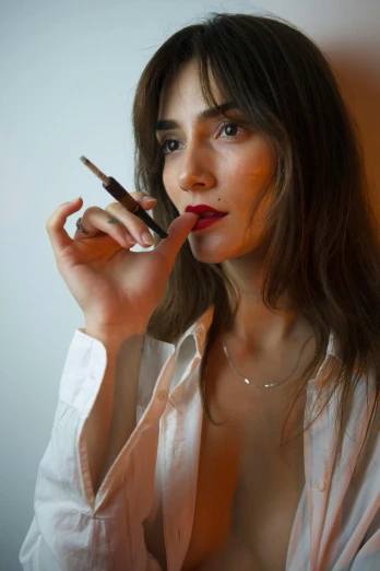 a woman with a topless  smoking a cigarette