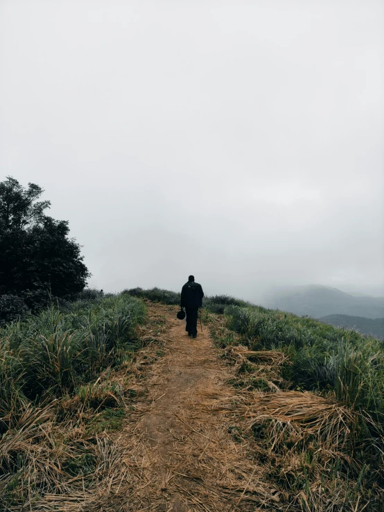 the man is walking down the road alone